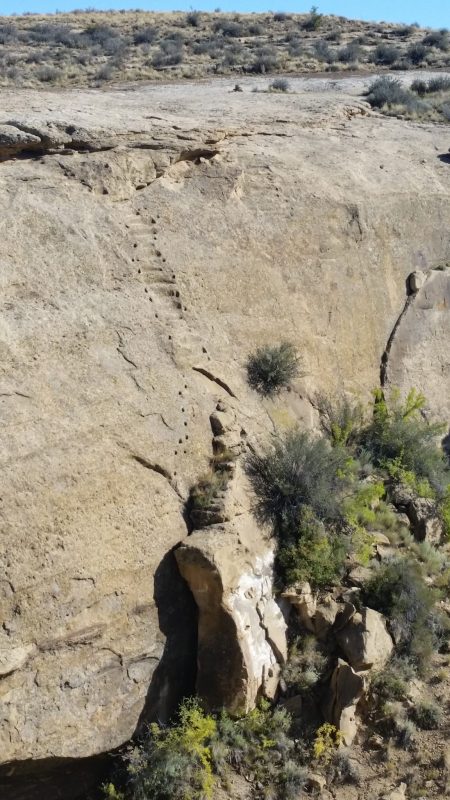 Weathered stairs carved into the side of a rock cliff in Chaco Canyon National Historical Park in New Mexico.