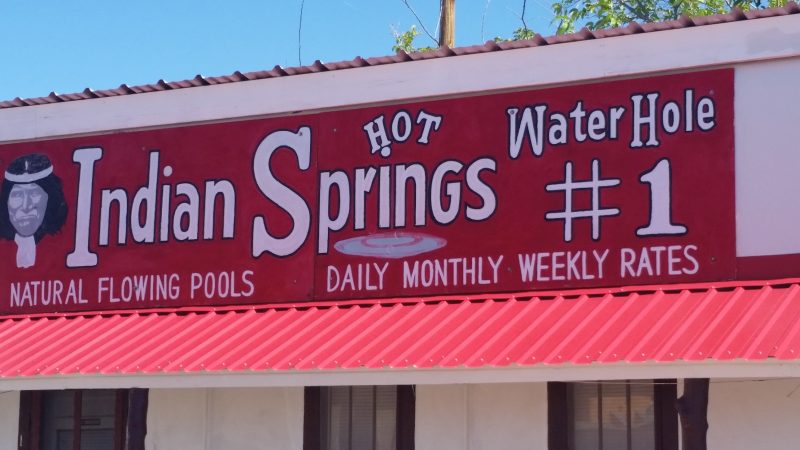 A red sign advertising Indian Springs Baths in Truth or Consequences, New Mexico.