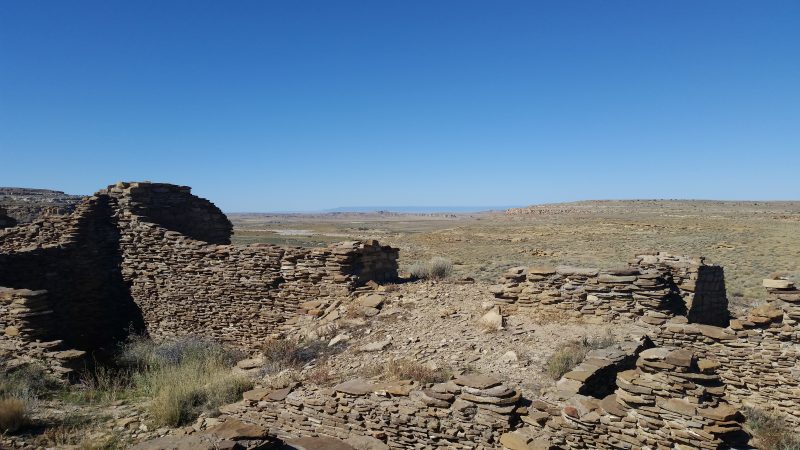 Penasco Blanco Ruins in Chaco Canyon against a clear blur sky.