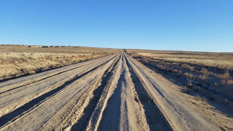 A badly rutted dirt road stretching into the horizon.