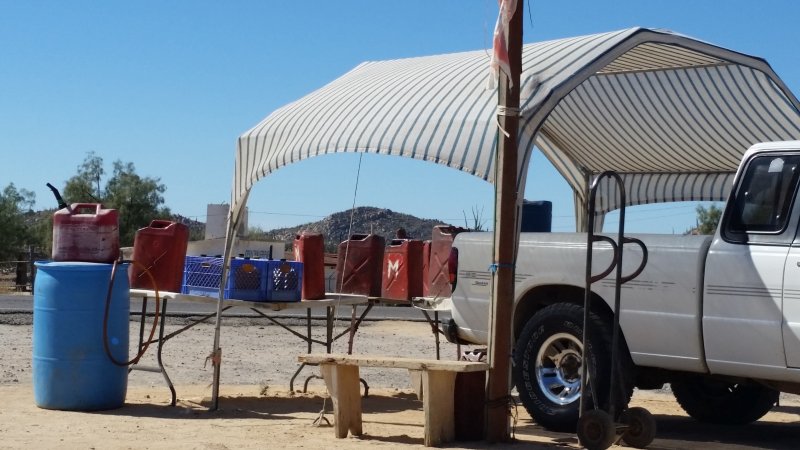 A truck with a canopy selling cans of gas to vehicles driving in Baja California along the Transpenisular Highway.