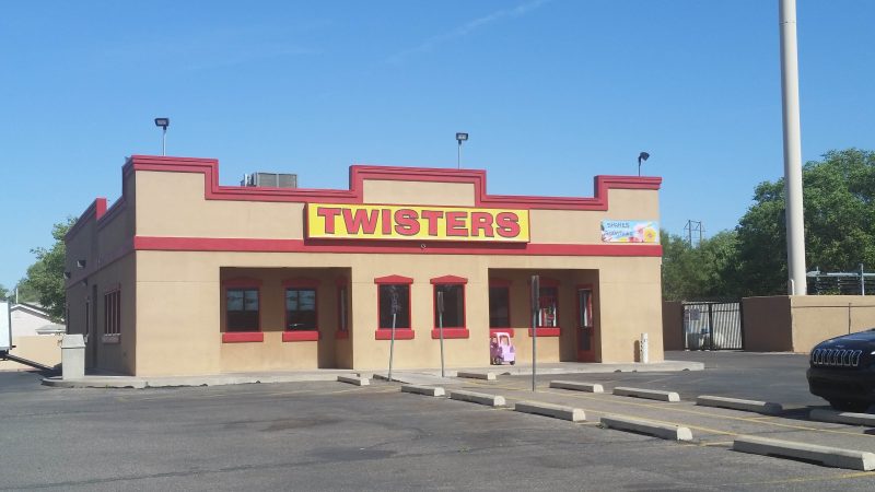 Beige one-storey building with red piping detail and a yellow and red sign advertising a Twisters restaurant on Isleta Blvd. in Albuquerque, New Mexico.