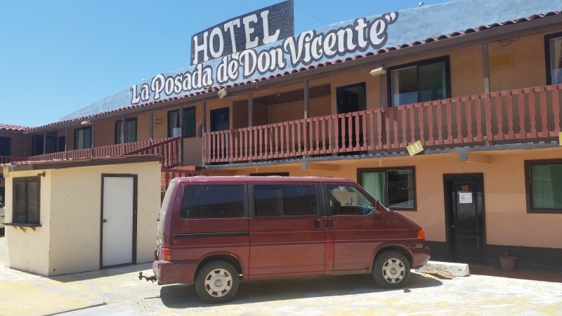 A maroon van outside of Hotel La Posada de Don Vincente in Guerrero Negro, a popular budget lodging option for drivers on Baja California trips down the length of the peninsula. 