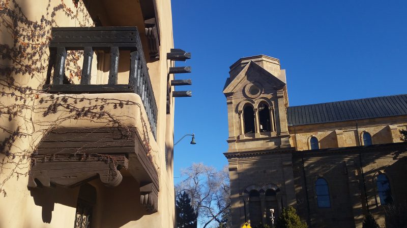 An adobe building and the bell tower of the Loretto Chapel in Santa Fe, New Mexico.