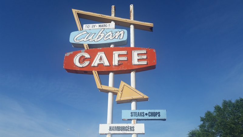 Googie-style red and blue sign advertising the Cuban Cafe on U.S. Highway 550, a popular route for road trips in New Mexico.