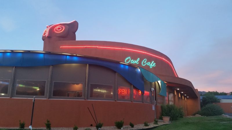 The Owl Cafe in Albuquerque with it's unique owl-shaped facade and neon lights illuminated at dusk.