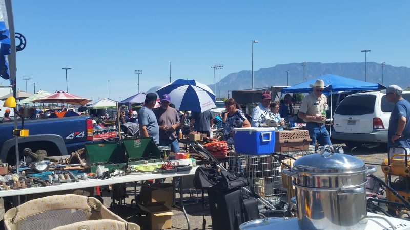 A diverse group of people browsing a variety of used goods at the Expo Flea Market, one of the weekly free things to do in Albuquerque.