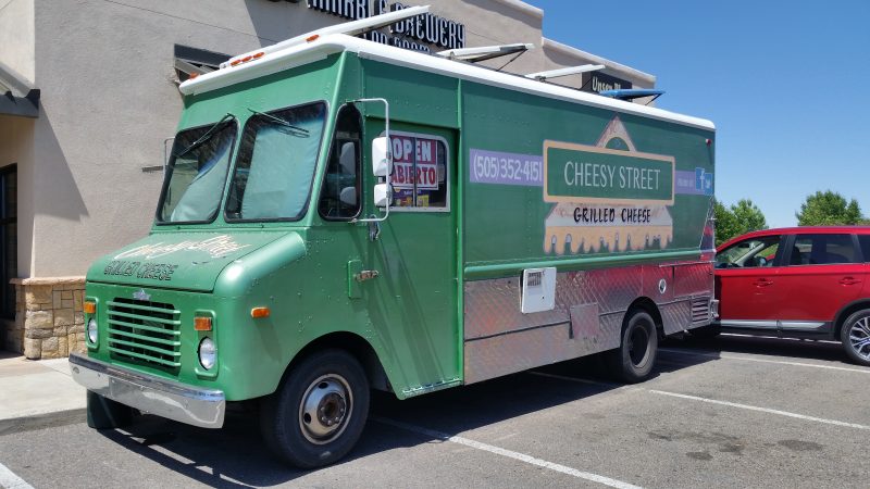 Green food truck with grilled cheese sandwich painted on the side.