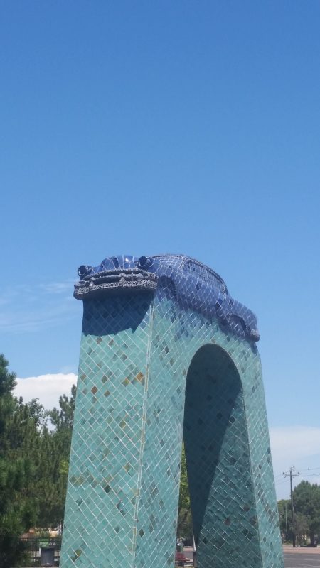 The unique Albuquerque landmark of a blue tiled Chevrolet sedan on top of a green tiled archway.