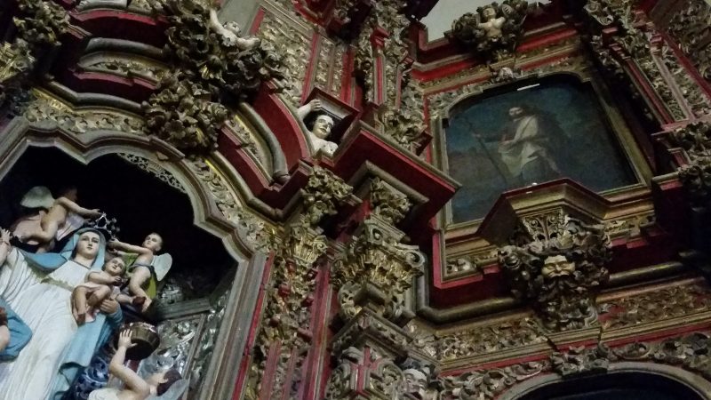 An elaborate red and gold painted carved wooden transept from the Temple of San Francisco in Chihuahua, Mexico.