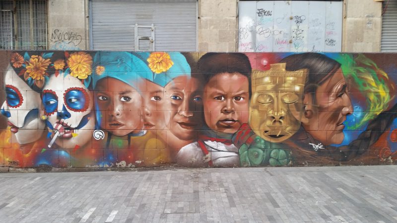 A colorful mural in Mexico City depicting many different faces.