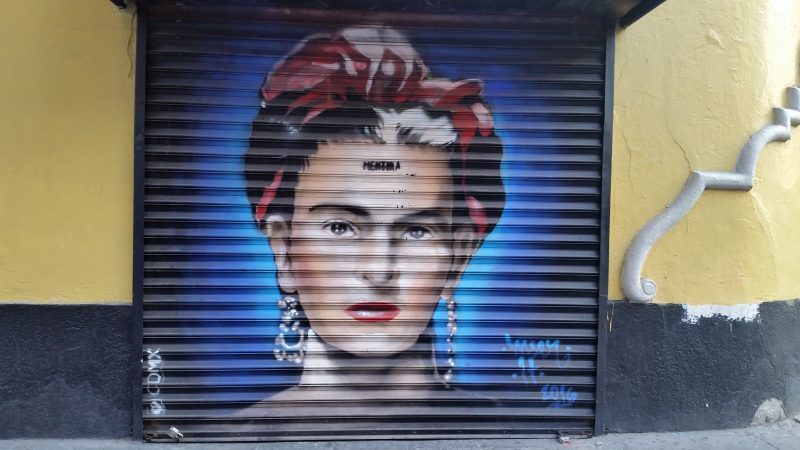 A spray painted image of Frida Kahlo on a storefront's metal shutters in Mexico City.