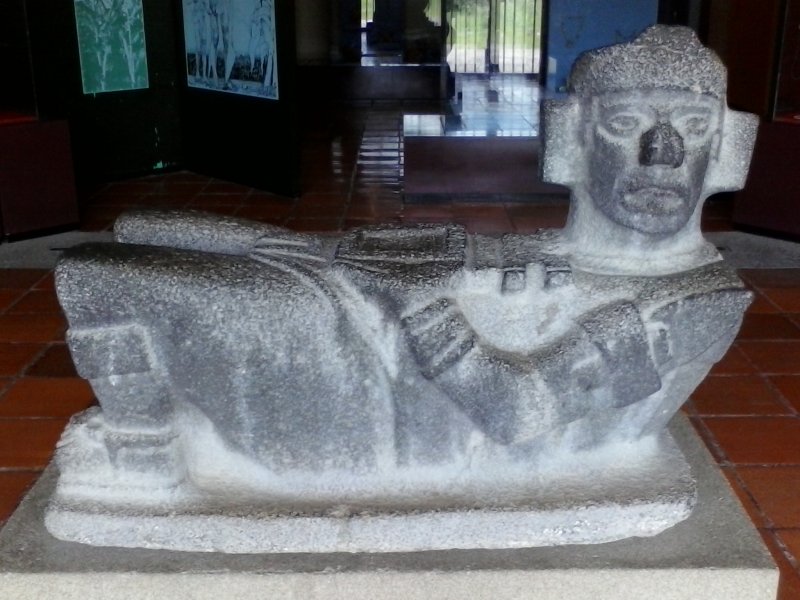 Grey-colored reclining Chac Mool statue at a museum in Tula, Mexico.