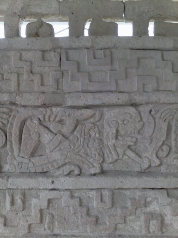 carved stone panel of man being eaten by a snake in Tula, Mexico.