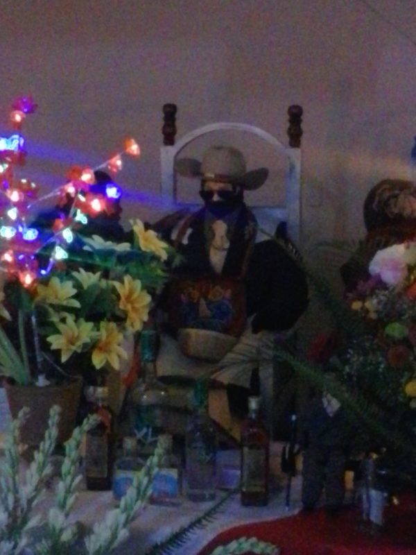 The likeness of San Simon in Zunil, Guatemala, wearing a sombrero and sunglasses, as is typical.