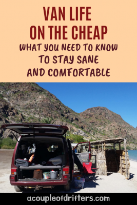 A burgundy camper van on a beach in Baja California with the back door open.