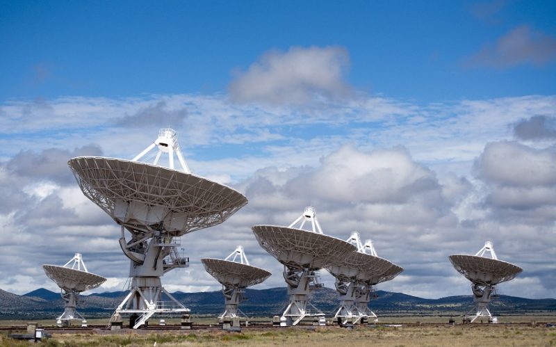 Several large radio telescopes pointing into the sky.