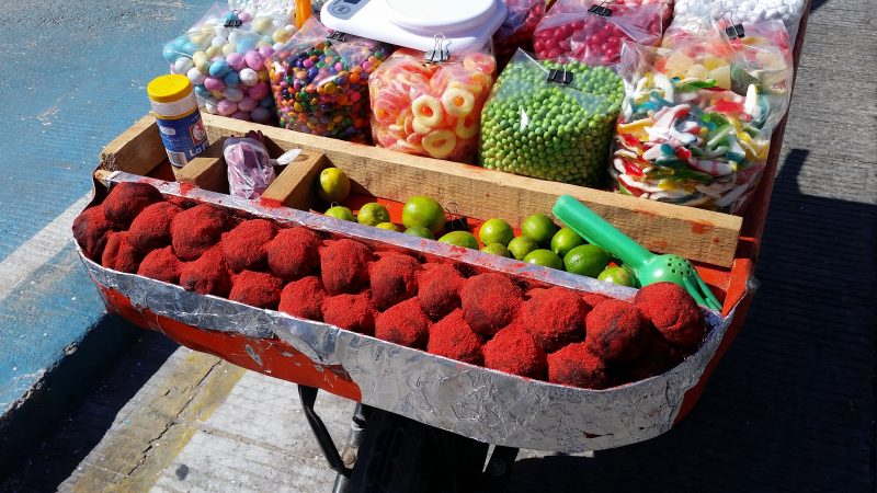 A cart full of assorted candies being sold by a street food vendor in Mexico.
